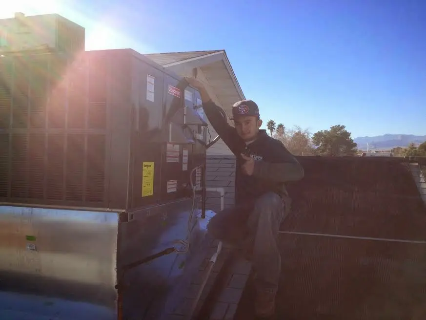 HVAC technician performing Heat Pump Repair on a rooftop unit in St. Robert